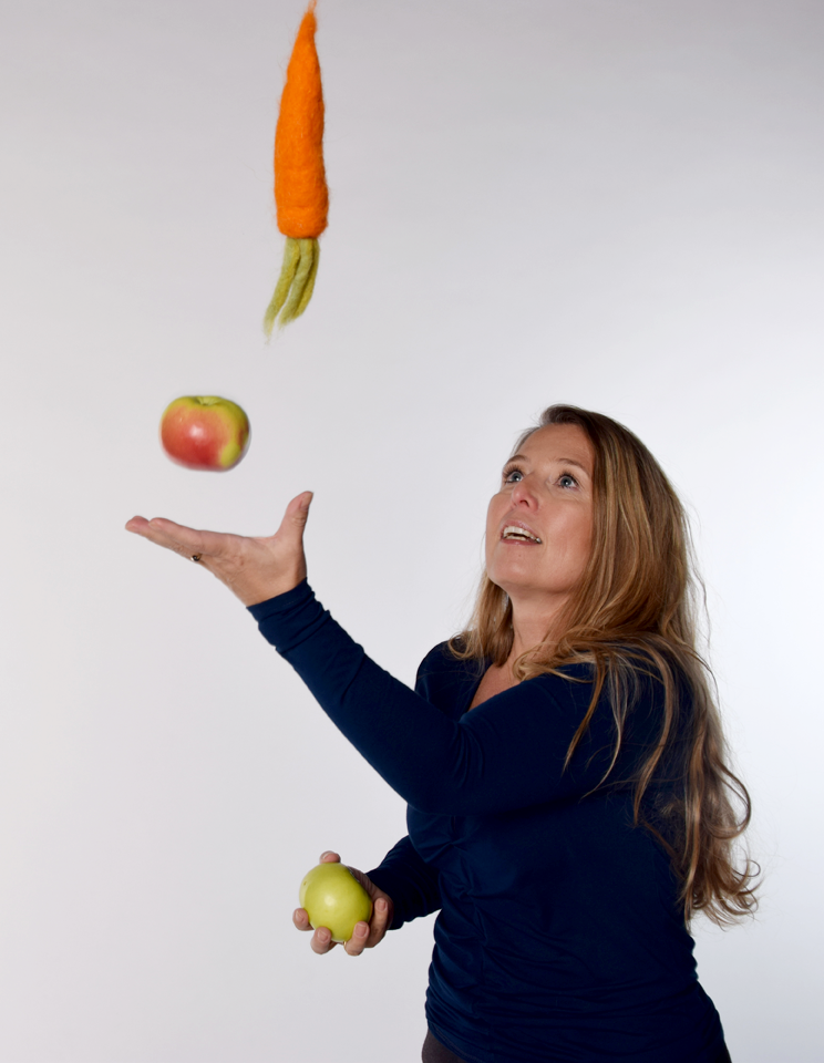 Frau beim Jonglieren von Obst und Gemüse